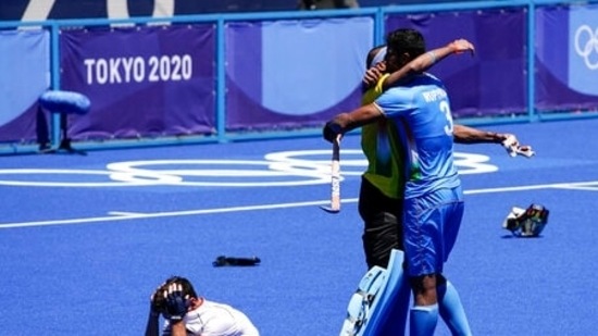 India's Rupinder Pal Singh (3) hugs goalkeeper Sreejesh Parattu Raveendran as Germany's Lukas Windfeder (4) reacts after India won their men's field hockey bronze medal match 5-4 at the 2020 Summer Olympics, Thursday, Aug. 5, 2021, in Tokyo, Japan. (AP Photo/John Locher)(AP)