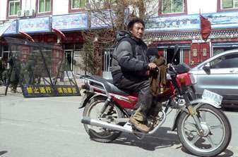 A Tibetan passes by on his bike as Chinese paramilitary police and riot police stand guard near barricades in China's Sichuan province. AP Photo/Gillian Wong A Tibetan passes by on his bike as Chinese paramilitary police and riot police stand guard near barricades in China's Sichuan province. AP Photo/Gillian Wong