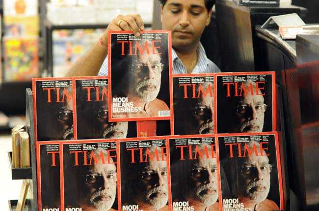 A vendor arranges copies of Time magazine featuring a cover photo of Modi with the caption "Modi means business but can he lead India". AFP Photo A vendor arranges copies of Time magazine featuring a cover photo of Modi with the caption "Modi means business but can he lead India". AFP Photo