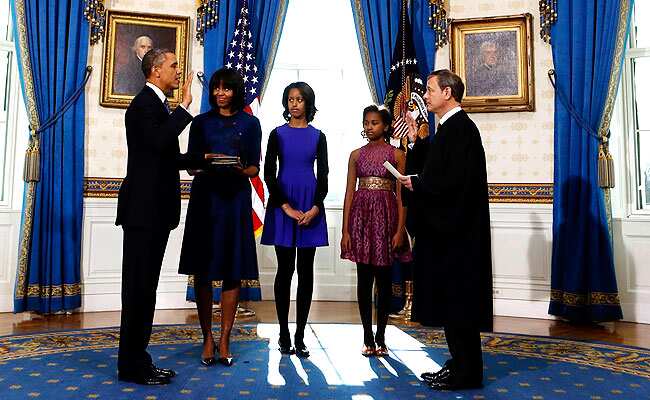 US President Barack Obama (L) takes the oath of office from US Supreme Court Chief Justice John Roberts as first lady Michelle Obama holds the bible and their daughters Malia and Sasha (L-R) look on in the Blue Room of the White House in Washington. Reuters </div) US President Barack Obama (L) takes the oath of office from US Supreme Court Chief Justice John Roberts as first lady Michelle Obama holds the bible and their daughters Malia and Sasha (L-R) look on in the Blue Room of the White House in Washington. Reuters </div)