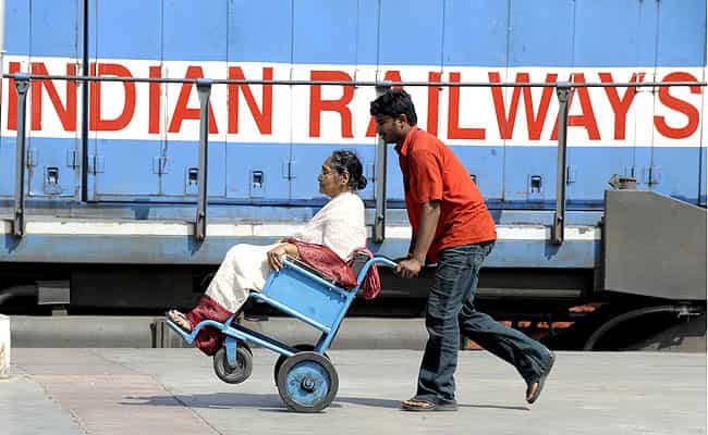A railway porter shifts a passenger in a wheelchair at a railway station in Hyderabad. AFP A railway porter shifts a passenger in a wheelchair at a railway station in Hyderabad. AFP