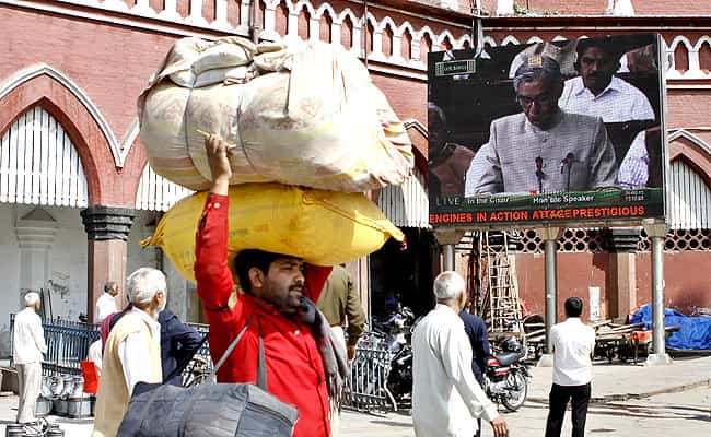 A coolie is seen near a screen outside the Old Delhi Railway station showing Bansal presenting the Rail Budget. HT/Sunil Saxena A coolie is seen near a screen outside the Old Delhi Railway station showing Bansal presenting the Rail Budget. HT/Sunil Saxena