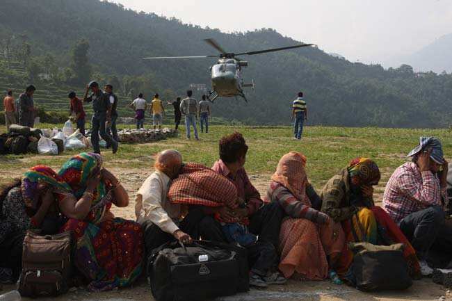 In this handout photograph released by the Ministry of Defence, rescued flood evacuees (foreground) cover their faces as an Indian Air Force HAL Dhruv utility helicopter flying rescue sorties over the Kedarnath valley in Uttarakhand state prepares to land in Ghauri Kund. AFP PHOTO </div) In this handout photograph released by the Ministry of Defence, rescued flood evacuees (foreground) cover their faces as an Indian Air Force HAL Dhruv utility helicopter flying rescue sorties over the Kedarnath valley in Uttarakhand state prepares to land in Ghauri Kund. AFP PHOTO </div)