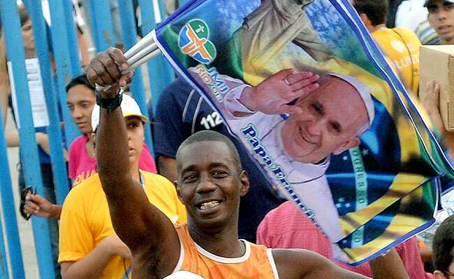 A peddler sells flags with the image of Pope Francis near the Guanabara Palace in Rio de Janeiro. AFP PHOTO A peddler sells flags with the image of Pope Francis near the Guanabara Palace in Rio de Janeiro. AFP PHOTO