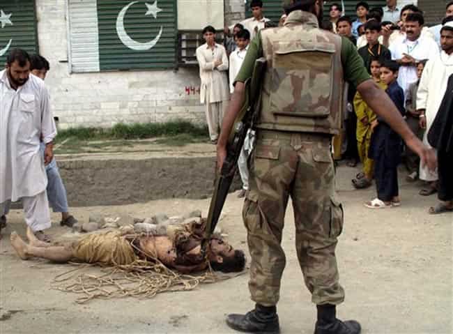 In this April 26, 2010 photo, Pakistani residents of Kanju in Pakistan's troubled Swat valley look at a dead body of an alleged militant, killed by security forces. Pakistan has spent nearly five years under civilian rule, an unusually long stretch for a 65-year-old country prone to military coups. But as the firing squad footage and several other prominent scandals suggest, the army remains largely unwilling to hold itself accountable to the public. (AP Photo/Sherin Zada, File)