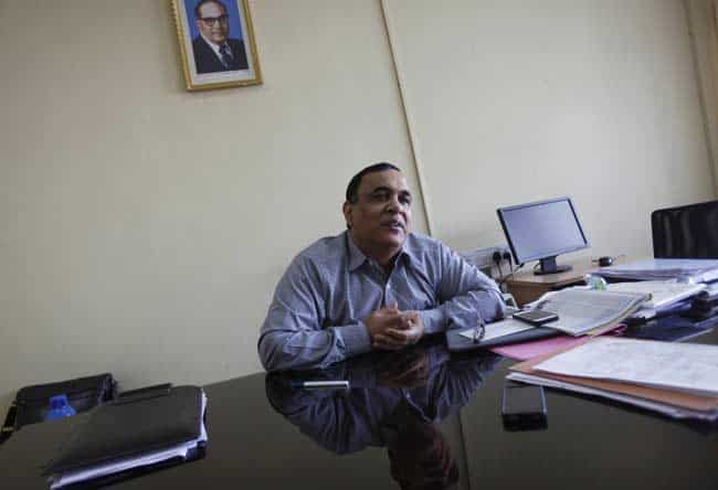 In this Dec. 3, 2012 photo, a portrait of Bhimrao Ramji Ambedkar, a dalit leader and architect of the Indian Constitution, hangs on the wall as Rajeev Chawla, the government administrator who created Bhoomi, a program that digitized Karnataka state's 20 million handwritten land records, speaks to The Associated Press at his office in Bangalore, India. For years, Karnataka's land records were a quagmire of disputed, forged documents maintained by thousands of tyrannical bureaucrats who demanded bribes to do their jobs. In 2002, there were hopes that this was about to change. Photo: AP/Aijaz Rahi In this Dec. 3, 2012 photo, a portrait of Bhimrao Ramji Ambedkar, a dalit leader and architect of the Indian Constitution, hangs on the wall as Rajeev Chawla, the government administrator who created Bhoomi, a program that digitized Karnataka state's 20 million handwritten land records, speaks to The Associated Press at his office in Bangalore, India. For years, Karnataka's land records were a quagmire of disputed, forged documents maintained by thousands of tyrannical bureaucrats who demanded bribes to do their jobs. In 2002, there were hopes that this was about to change. Photo: AP/Aijaz Rahi