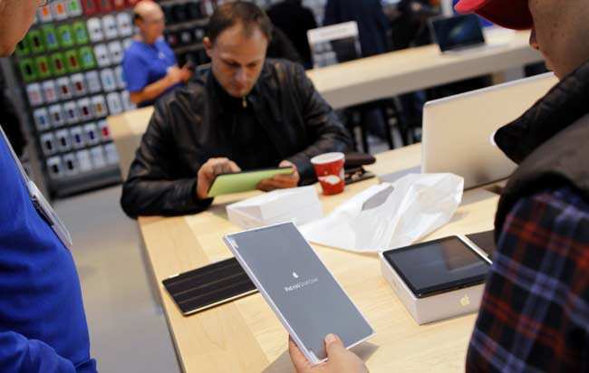 Customers look over the iPad mini after the device went on sale at Apple's retail store in Palo Alto, California in this November 2, 2012 file photograph. Reuters/Robert Galbraith/Files