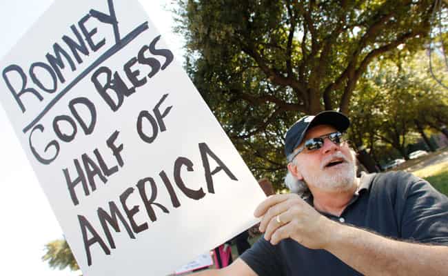 Mickey Corsi, of Bedford, Texas, holds a sign as he protests outside the hotel hosting a fundraiser for US Republican presidential candidate Mitt Romney in Dallas. AP