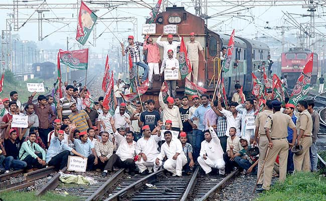 Demonstrators from the Samajwadi Party shout slogans after they stopped a passenger train during a protest against price hikes in fuel and FDI near Allahabad railway station. Reuters Photo