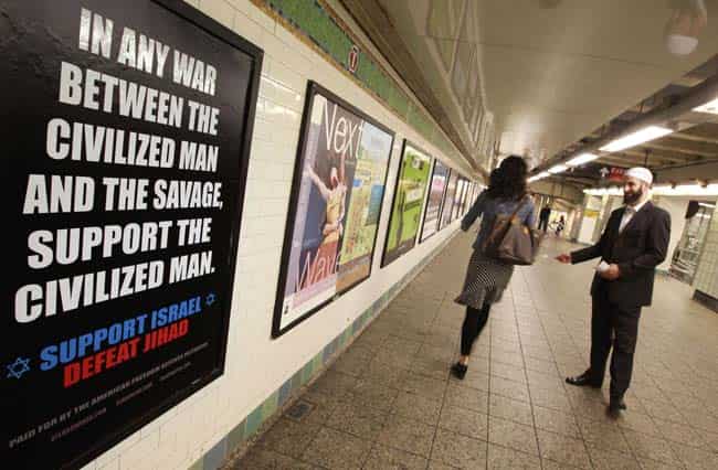 A member of the council on American-Islamic relations attempts to talk to a woman as she walks by an advertisement that reads "Support Israel/Defeat Jihad" in the Times Square subway station. Reuters/Brendan Mcdermid