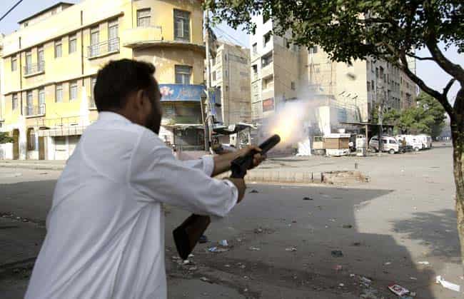 A plain clothed Pakistani police officer fires a tear gas canister to disperse protesters, not shown, during clashes in Karachi on Friday. Demonstrations turned violent in several Pakistani cities and over a dozen people were killed as tens of thousands protested against an anti-Muslim film produced in the United States and vulgar caricatures of the Prophet Muhammad published in a French satirical weekly around the country after the government encouraged peaceful protests and declared a national holiday labelled "Love for the Prophet Day." (AP Photo/Fareed Khan)
</div) A plain clothed Pakistani police officer fires a tear gas canister to disperse protesters, not shown, during clashes in Karachi on Friday. Demonstrations turned violent in several Pakistani cities and over a dozen people were killed as tens of thousands protested against an anti-Muslim film produced in the United States and vulgar caricatures of the Prophet Muhammad published in a French satirical weekly around the country after the government encouraged peaceful protests and declared a national holiday labelled "Love for the Prophet Day." (AP Photo/Fareed Khan)
</div)