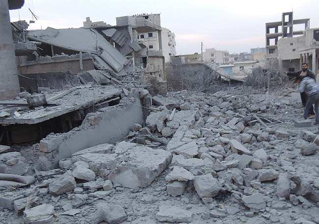 Residents gesture near buildings damaged by what activists said were missiles fired by a Syrian Air Force fighter jet loyal to President Bashar al-Assad in Binsh near Idlib January 2, 2013. Reuters/Muhammad Najdet Qadour/Shaam News Network/Handout Residents gesture near buildings damaged by what activists said were missiles fired by a Syrian Air Force fighter jet loyal to President Bashar al-Assad in Binsh near Idlib January 2, 2013. Reuters/Muhammad Najdet Qadour/Shaam News Network/Handout