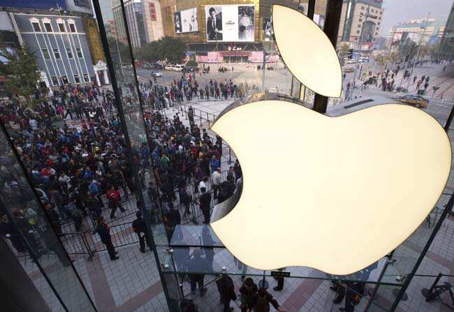 In this Oct. 20, 2012 photo, people line up to enter a newly-opened Apple Store in Wangfujing shopping district in Beijing. Apple's profit surge halted in the latest quarter, as a flood of new products like the iPhone 5 meant high start-up costs for new production lines.Photo: AP/Andy Wong, File In this Oct. 20, 2012 photo, people line up to enter a newly-opened Apple Store in Wangfujing shopping district in Beijing. Apple's profit surge halted in the latest quarter, as a flood of new products like the iPhone 5 meant high start-up costs for new production lines.Photo: AP/Andy Wong, File