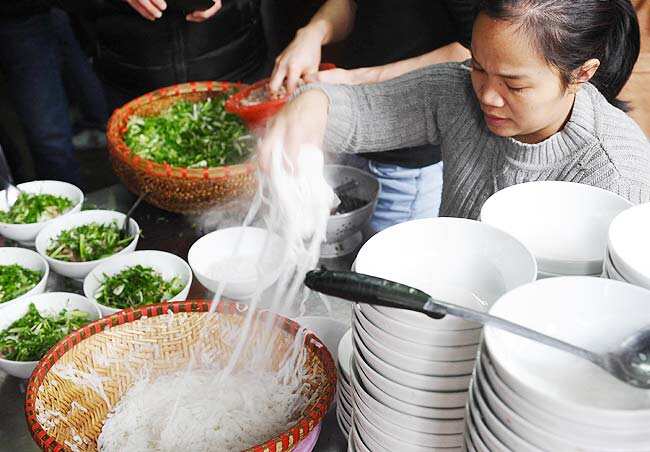 This picture taken on January 10, 2013 shows an employee placing pho noodles into bowls at Pho Thin restaurant in Hanoi. Photo: AFP / Hoang Dinh Nam This picture taken on January 10, 2013 shows an employee placing pho noodles into bowls at Pho Thin restaurant in Hanoi. Photo: AFP / Hoang Dinh Nam