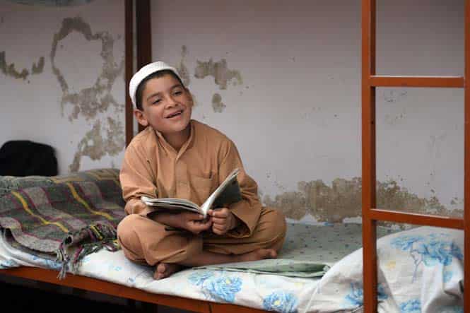 An Afghan orphan sits on his bed while studying at the Shiekh Zayed orphanage in Kandahar. (AFP Photo)
</div) An Afghan orphan sits on his bed while studying at the Shiekh Zayed orphanage in Kandahar. (AFP Photo)
</div)