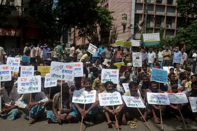 Hand-pulled rickshaw riders and cyclists sit with placards during a protest in Kolkata over a move to ban them from major roads. (AFP photo) Hand-pulled rickshaw riders and cyclists sit with placards during a protest in Kolkata over a move to ban them from major roads. (AFP photo)