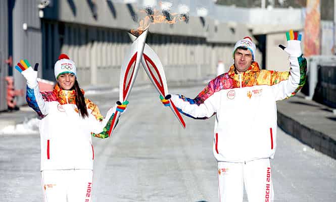 In this photo provided by Olympictorch2014.com torch bearers Yulia Bozhenova and Alexei Soloviev hold their torches during the Olympic torch relay in southern Siberi, Russia. (AP Photo)
</div) In this photo provided by Olympictorch2014.com torch bearers Yulia Bozhenova and Alexei Soloviev hold their torches during the Olympic torch relay in southern Siberi, Russia. (AP Photo)
</div)