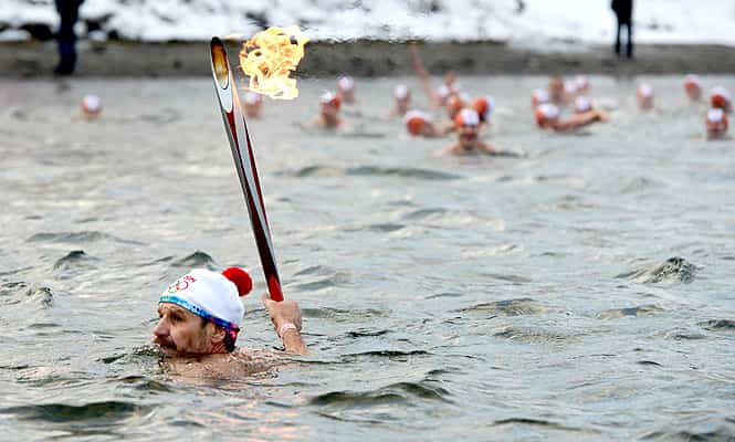 A handout picture released by the Sochi 2014 Winter Olympics Organising Committee shows swimming champion Nikolai Petshak carrying an Olympic torch. (AFP Photo/Sochi 2014 Organising Committee)
</div) A handout picture released by the Sochi 2014 Winter Olympics Organising Committee shows swimming champion Nikolai Petshak carrying an Olympic torch. (AFP Photo/Sochi 2014 Organising Committee)
</div)