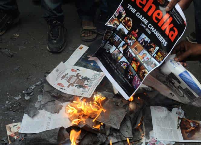 ABVP activists burning copies of promotional papers of Tehelka magazine during a protest against Tarun Tejpal outside Tehelka's office in New Delhi. (PTI Photo) 
</div)