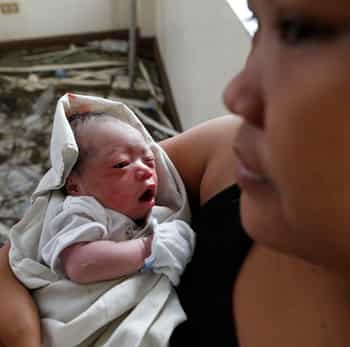 A woman holds newly born baby Beatriz at a makeshift birthing clinic in Tacloban city in Philippines. (Reuters photo)
</div) A woman holds newly born baby Beatriz at a makeshift birthing clinic in Tacloban city in Philippines. (Reuters photo)
</div)