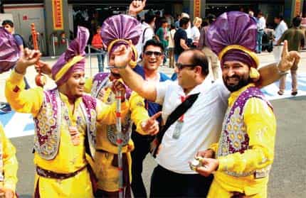 Paddock guests enjoy a carnival-like atmosphere. This year, a bhangra troupe danced around the pit
