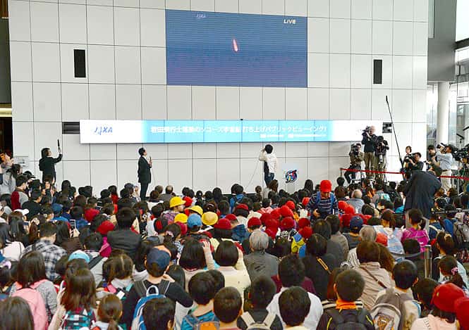 People gather to watch a live public broadcast showing Russia's Soyuz spacecraft carrying the Olympic torch for the 2014 Winter Games in Sochi aboard in Tokyo. (AFP photo)</em) People gather to watch a live public broadcast showing Russia's Soyuz spacecraft carrying the Olympic torch for the 2014 Winter Games in Sochi aboard in Tokyo. (AFP photo)</em)