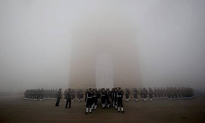 A blanket of fog covers India Gate in New Delhi. (PTI)</font></em></strong)