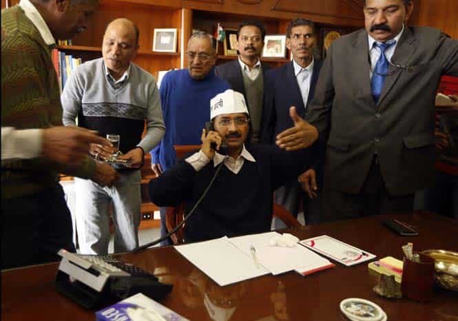 Delhi CM Arvind Kejriwal talks on a phone as he is seated to assume the office in New Delhi. (AP photo)</strong) Delhi CM Arvind Kejriwal talks on a phone as he is seated to assume the office in New Delhi. (AP photo)</strong)