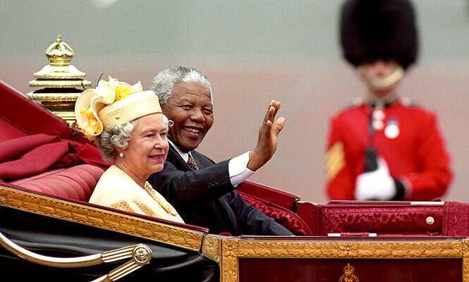 A July 9, 1996 file photo of Nelson Mandela, former president of South Africa, and Britain's Queen Elizabeth II riding in a carriage along the Mall, London. (AP Photo)
</div) A July 9, 1996 file photo of Nelson Mandela, former president of South Africa, and Britain's Queen Elizabeth II riding in a carriage along the Mall, London. (AP Photo)
</div)