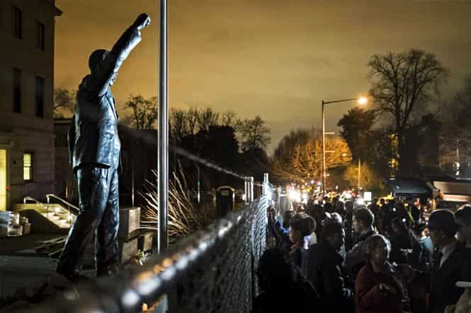 A crowd gathers outside the South Africa embassy near a statue of Nelson Mandela, after his passing, in Washington. (Reuters Photo)
</div) A crowd gathers outside the South Africa embassy near a statue of Nelson Mandela, after his passing, in Washington. (Reuters Photo)
</div)