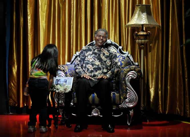 A visitor reads an obituary next to a wax figure of late Nelson Mandela at the i-City Red Carpet Wax Museum in Shah Alam, Malaysia. (AFP photo)</strong) A visitor reads an obituary next to a wax figure of late Nelson Mandela at the i-City Red Carpet Wax Museum in Shah Alam, Malaysia. (AFP photo)</strong)
