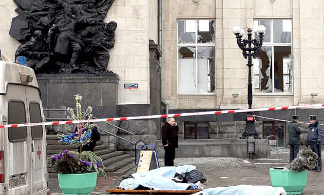 The covered bodies of victims lie on the ground as Russian security personnel inspect the scene of a suicide attack at a train station in the Volga River city of Volgograd. (AFP Photo)
</div) The covered bodies of victims lie on the ground as Russian security personnel inspect the scene of a suicide attack at a train station in the Volga River city of Volgograd. (AFP Photo)
</div)