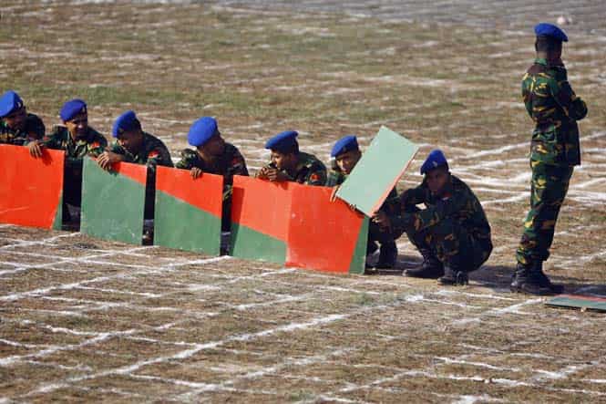 Members of Bangladesh Army wait to participate in the formation of the national flag during Victory Day celebrations in Dhaka. (AP photo)</em)