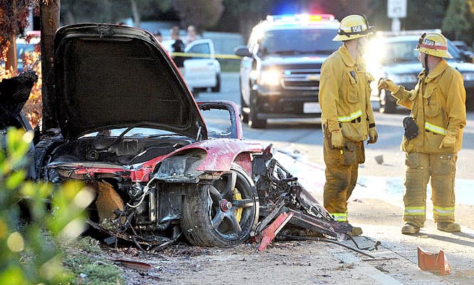 First responders gather evidence near the wreckage of a Porsche sports car that crashed into a light pole on Hercules Street near Kelly Johnson Parkway in Valencia. (AP photo)</em) First responders gather evidence near the wreckage of a Porsche sports car that crashed into a light pole on Hercules Street near Kelly Johnson Parkway in Valencia. (AP photo)</em)