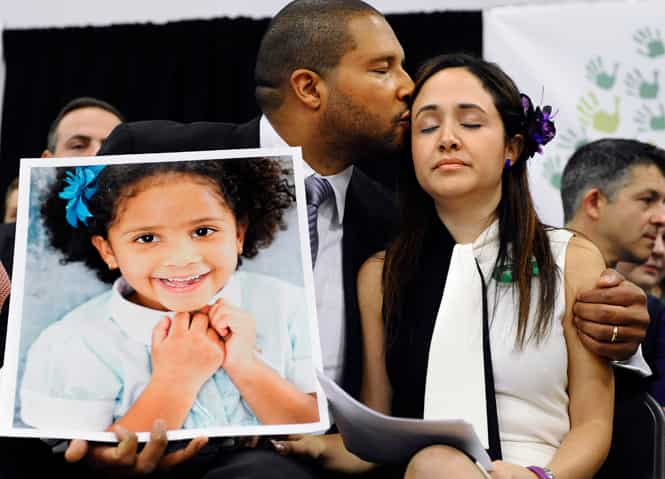 Jimmy Greene kisses his wife Nelba Marquez-Greene while holding a portrait of their daughter, Ana Marquez-Greene, a victim of the mass shooting, in Newtown. (AP file photo)</em) Jimmy Greene kisses his wife Nelba Marquez-Greene while holding a portrait of their daughter, Ana Marquez-Greene, a victim of the mass shooting, in Newtown. (AP file photo)</em)