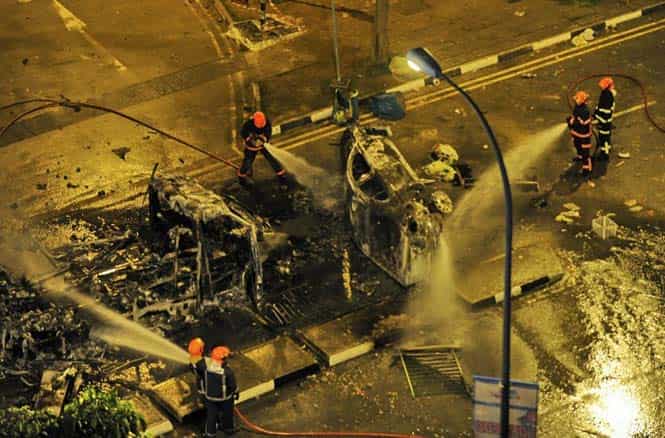 Firemen douse a charred ambulance after a rare riot broke out in Singapore among South Asian workers in Little India district. (AFP photo) Firemen douse a charred ambulance after a rare riot broke out in Singapore among South Asian workers in Little India district. (AFP photo)