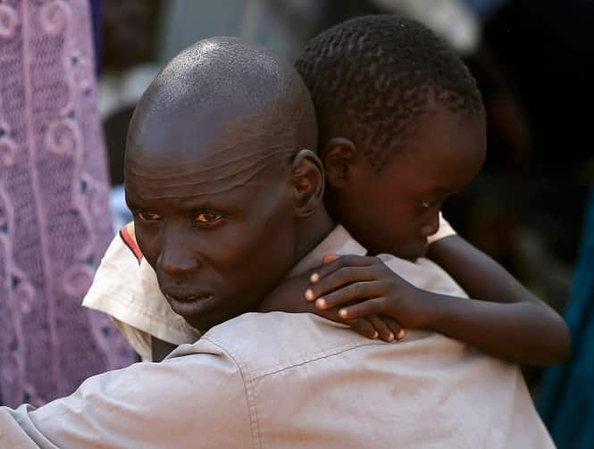 An internally displaced man holds his son inside a United Nations Missions in Sudan compound in Juba. (Reuters Photo)</em) An internally displaced man holds his son inside a United Nations Missions in Sudan compound in Juba. (Reuters Photo)</em)