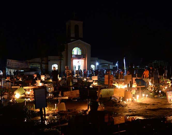 Survivors of super typhoon Haiyan visit the grave of relatives at a mass grave for victims of the disaster in front of a chapel in Palo, before attending a traditional Christmas eve mass. (AFP)</font></em></strong) Survivors of super typhoon Haiyan visit the grave of relatives at a mass grave for victims of the disaster in front of a chapel in Palo, before attending a traditional Christmas eve mass. (AFP)</font></em></strong)