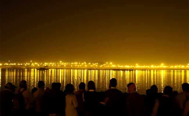 Crowds gather for the
evening
aarti, while the mela across the river lights up the opposite bank Crowds gather for the
evening
aarti, while the mela across the river lights up the opposite bank