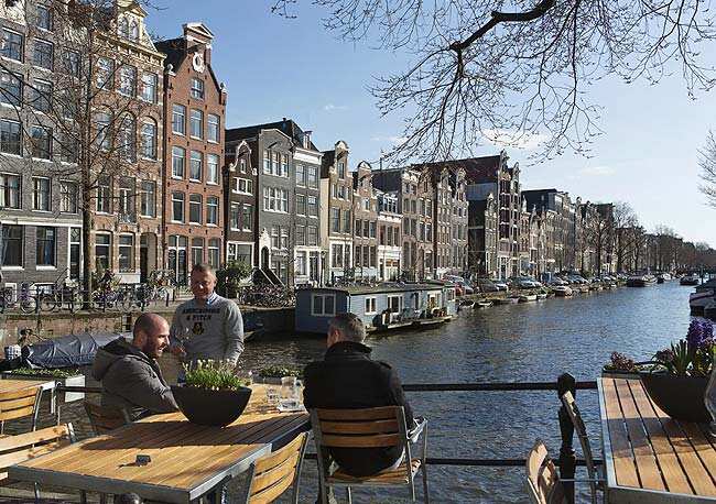 Men enjoy the afternoon sun at the Brouwersgracht canal in Amsterdam. Reuters/Michael Kooren