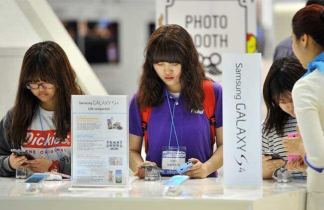 Visitors looking at Samsung Electronics smartphone Galaxy S4 during an IT show in Seoul. Photo: AFP / Jung Yeon-Je Visitors looking at Samsung Electronics smartphone Galaxy S4 during an IT show in Seoul. Photo: AFP / Jung Yeon-Je