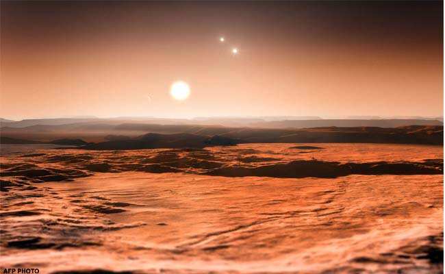 A handout photo provided by the European Southern Observatory (ESO) shows an artist’s impression of the view from the exoplanet Gliese 667Cd looking towards the planet’s parent star (Gliese 667C). In the background to the right, the more distant stars in this triple system (Gliese 667A and Gliese 667B) are visible and to the left in the sky one of the other planets, the newly discovered Gliese 667Ce, can be seen as a crescent. A record-breaking three planets in this system are super-Earths lying in the zone around the star where liquid water could exist, making them possible candidates for the presence of life. This is the first system found with a fully packed habitable zone. (AFP Photo/ESO/M. Kornmesser) A handout photo provided by the European Southern Observatory (ESO) shows an artist’s impression of the view from the exoplanet Gliese 667Cd looking towards the planet’s parent star (Gliese 667C). In the background to the right, the more distant stars in this triple system (Gliese 667A and Gliese 667B) are visible and to the left in the sky one of the other planets, the newly discovered Gliese 667Ce, can be seen as a crescent. A record-breaking three planets in this system are super-Earths lying in the zone around the star where liquid water could exist, making them possible candidates for the presence of life. This is the first system found with a fully packed habitable zone. (AFP Photo/ESO/M. Kornmesser)