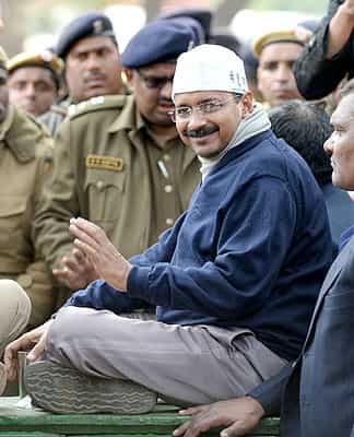 CM Kejriwal smiles as he sits during a protest outside Rail Bhawan, Delhi. (AFP photo)</strong> 
</div)