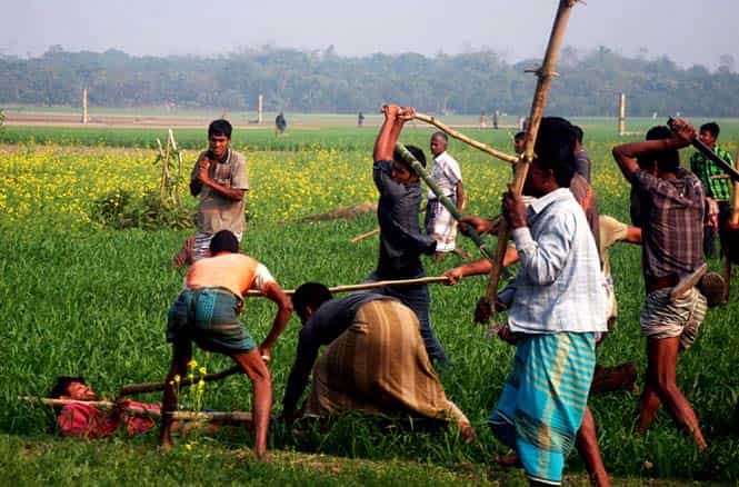 A Bangladeshi resident wanting to vote is attacked by protestors in a field in Rajshahi, some 260 kms from Dhaka. (AFP Photo)
</div) A Bangladeshi resident wanting to vote is attacked by protestors in a field in Rajshahi, some 260 kms from Dhaka. (AFP Photo)
</div)
