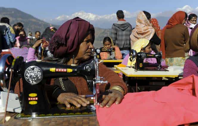 Widows, who lost their husbands during the massive Uttarakhand floods last June, take part in vocational training at Deoli-Bhanigram village in Uttarakhand. (AFP Photo) 
</div)