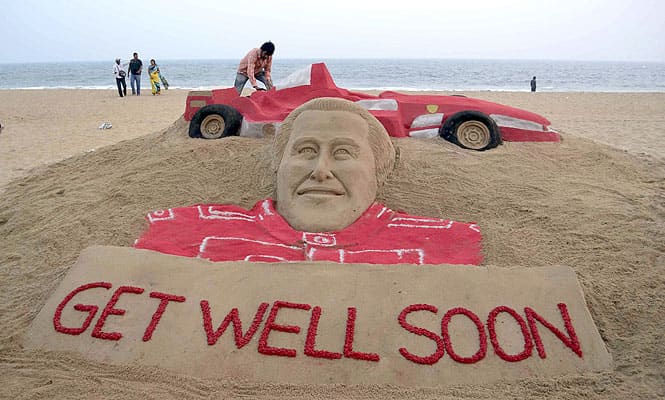 Visitors gather near a sculpture of Formula One great Michael Schumacher titled Get Well Soon by sand artist Sudarshan Patnaik at a beach in Puri, in Bhubaneswar. (AP Photo)
</div) Visitors gather near a sculpture of Formula One great Michael Schumacher titled Get Well Soon by sand artist Sudarshan Patnaik at a beach in Puri, in Bhubaneswar. (AP Photo)
</div)