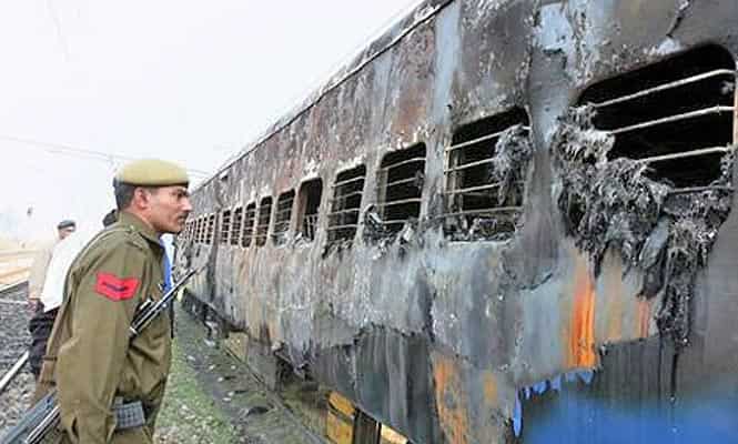 A security personnel looks at burnt bogies of Samjhauta Express near Deewana Village, Panipat. (FILE PHOTO/PTI Photo)
</div) A security personnel looks at burnt bogies of Samjhauta Express near Deewana Village, Panipat. (FILE PHOTO/PTI Photo)
</div)