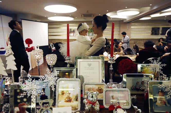 Kim Dot-byul is held by her mother as her pictures are displayed during her first birthday party or Doljanchi in Seoul. (Reuters photo)
</div) Kim Dot-byul is held by her mother as her pictures are displayed during her first birthday party or Doljanchi in Seoul. (Reuters photo)
</div)