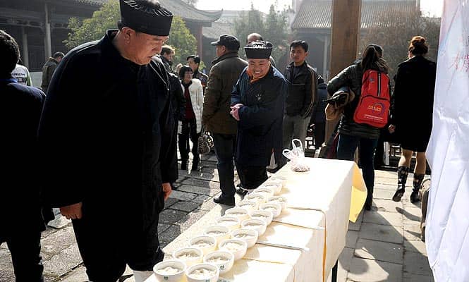 People looking at bowls of noodles placed on a desk during an eating race in Liuyang in China's central province of Hunan. (AFP)</font></strong)