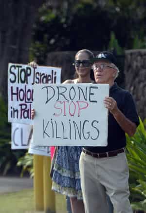 A group of protesters show placards as Obama's motorcade arrives at his vacation home in Kailua, Hawaii. (AFP photo)</strong>
</div) A group of protesters show placards as Obama's motorcade arrives at his vacation home in Kailua, Hawaii. (AFP photo)</strong>
</div)